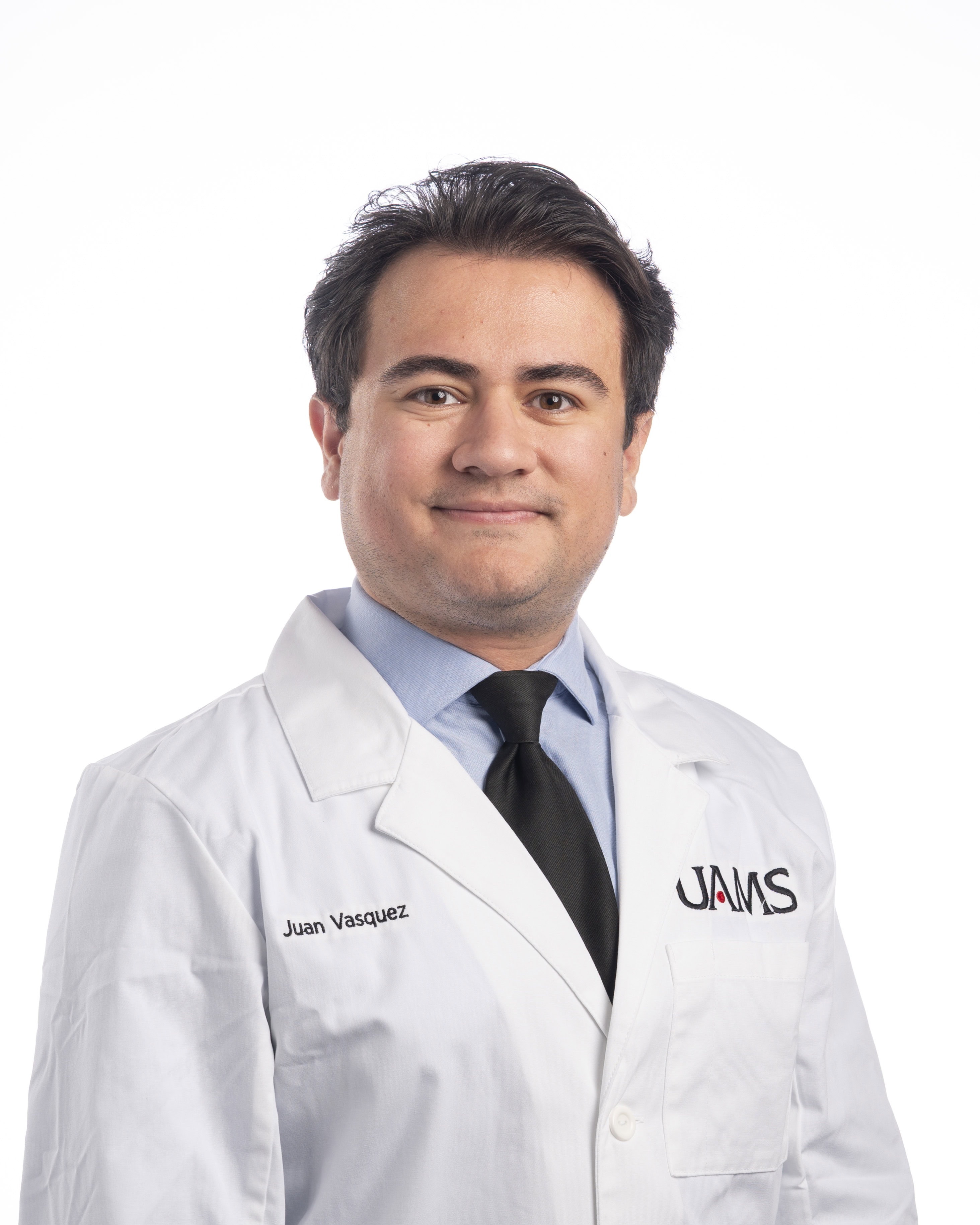 Juan Vasquez Professional headshot of Juan Vasquez in a white coat