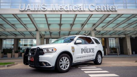A white UAMS Police vehicle parked in front of the UAMS Medical Center