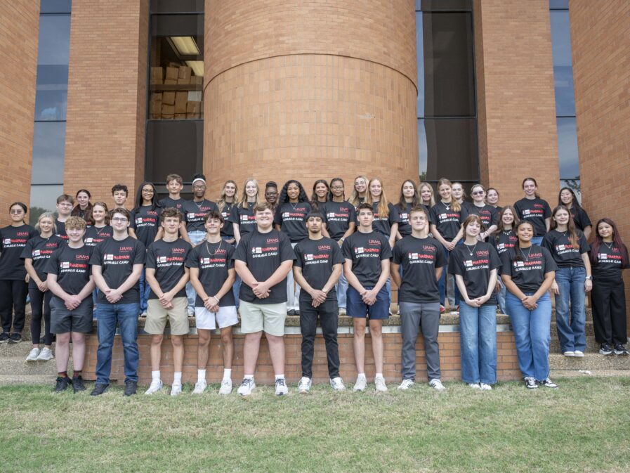 A large group of students wearing matching black shirts that say 