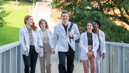 college of pharmacy students walking on bridge